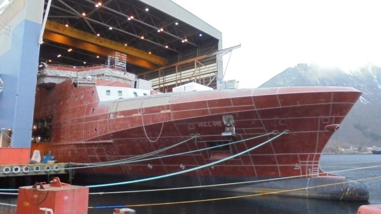 Baugen på det nye kystvaktskipet Jan Mayen stikker ut av hallen hvor det ligger i dokk.