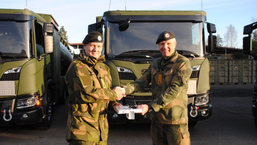 Her overrekker Tomas Beck, sjef Landkapasiteter i Forsvarsmateriell (t.h.) nøkler og teknisk håndbok til sjef FLO, brigader Anders Jernberg (t.v.) Foto: Forsvarets logistikkorganisasjon, FLO