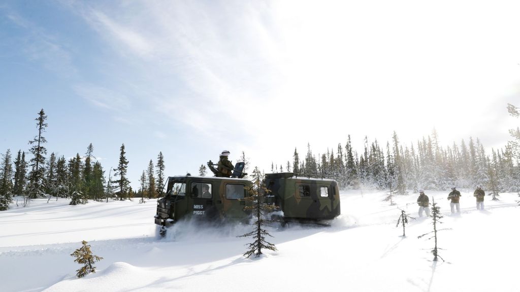 Soldater fra Forsvarets høgskole på vinterøvelse i Norge snørekjører på ski bak en beltevogn BV206. Foto: Torbjørn Kjosvold/Forsvaret