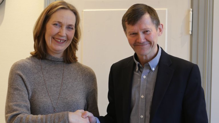 Mann og kvinne ser smilende mot fotografen