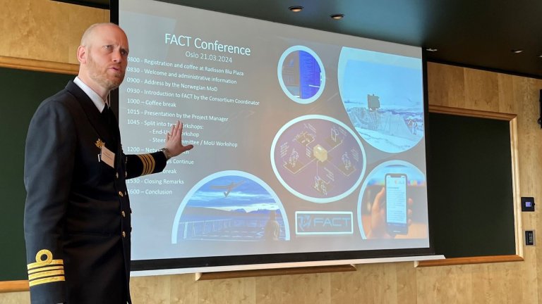 Mann i uniform holder foredrag foran et lerret med overskriften FACT Conference