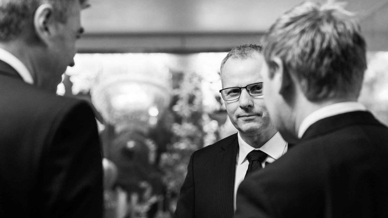 Tre dresskledde menn i samtale
