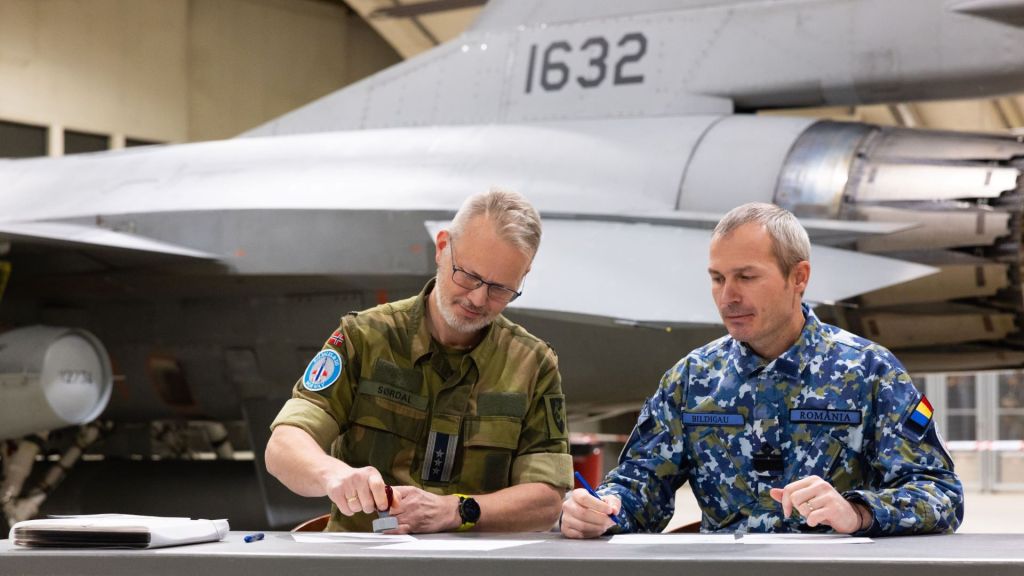 Oberst Eivind Sørdal og major Lurgo Bildigau signerer overføringspapirer i forbindelse med Romanias kjøp av norske F-16 på Rygge i november 2023. Foto: Fabian Helmersen/Forsvaret