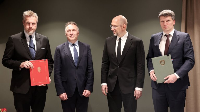 Fire dresskledde menn oppstilt foran kamera.