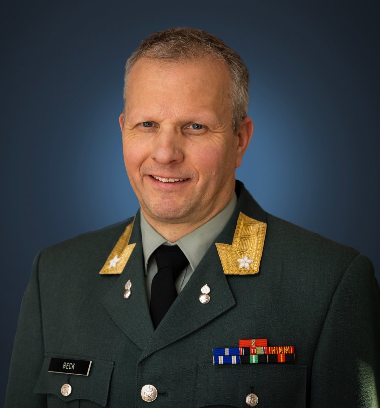 Mann i grønn militæruniform med distinksjoner og medaljer