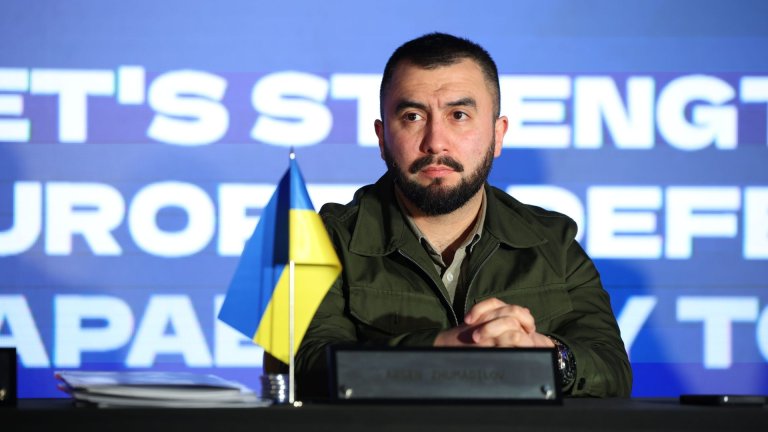 Mann sitter ved bord med ukrainsk flagg