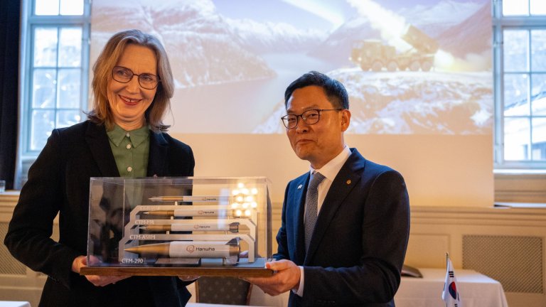 En kvinne og en mann holder en monter med modeller av missiler