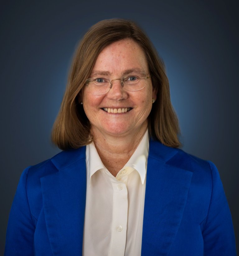 Smilende kvinne ikledd blå jakke