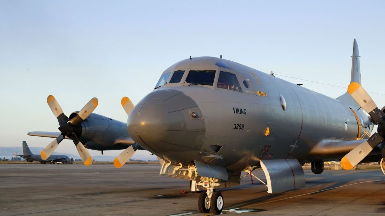 Et maritimt overvåkingsfly av typen P-3 Orion står parkert på en flyplass i dagslys, med propeller og skrog tydelig synlige.