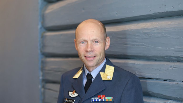 Man in uniform in front of a blue wall