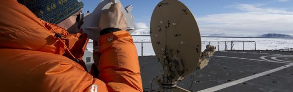 Satellittingeniør Vidar Madsen tester om løsningen fungerer mellom fjellene nord på Svalbard.